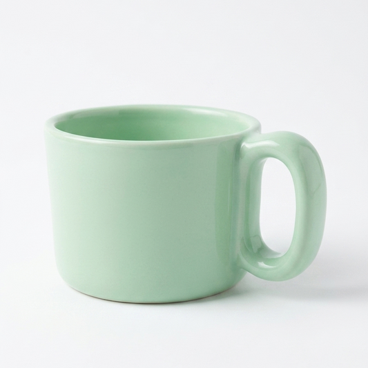A mint green ceramic mug with a rounded body and a uniquely shaped loop handle, shown on a clean white background.