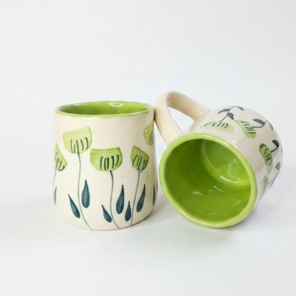 two green handpainted mugs in white background