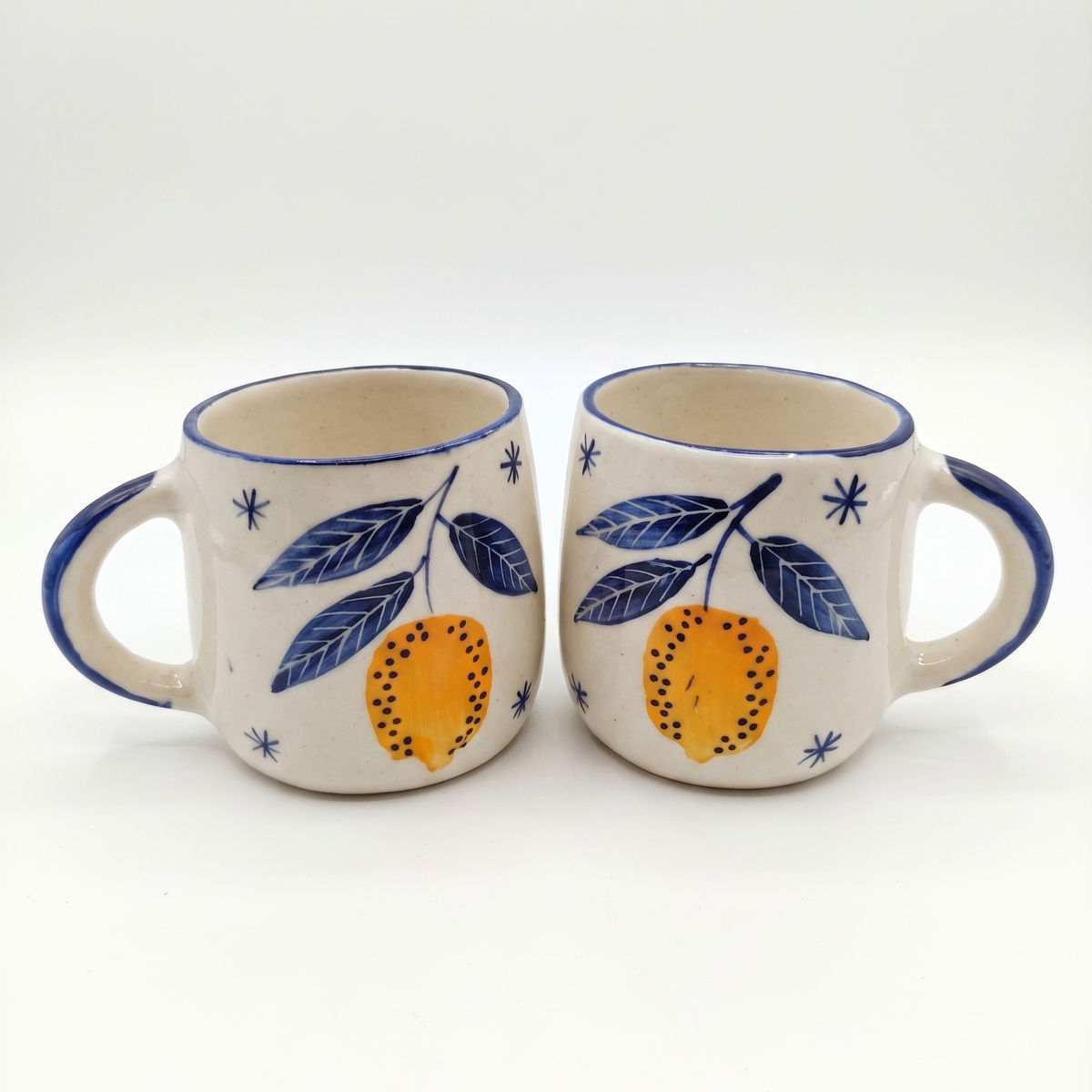 two lemon handpainted mugs on white background
