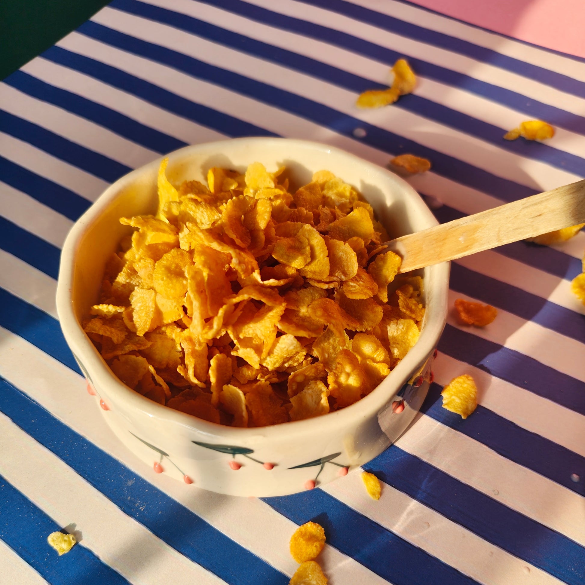 Snack bowl with cornflakes on a striped tablecloth