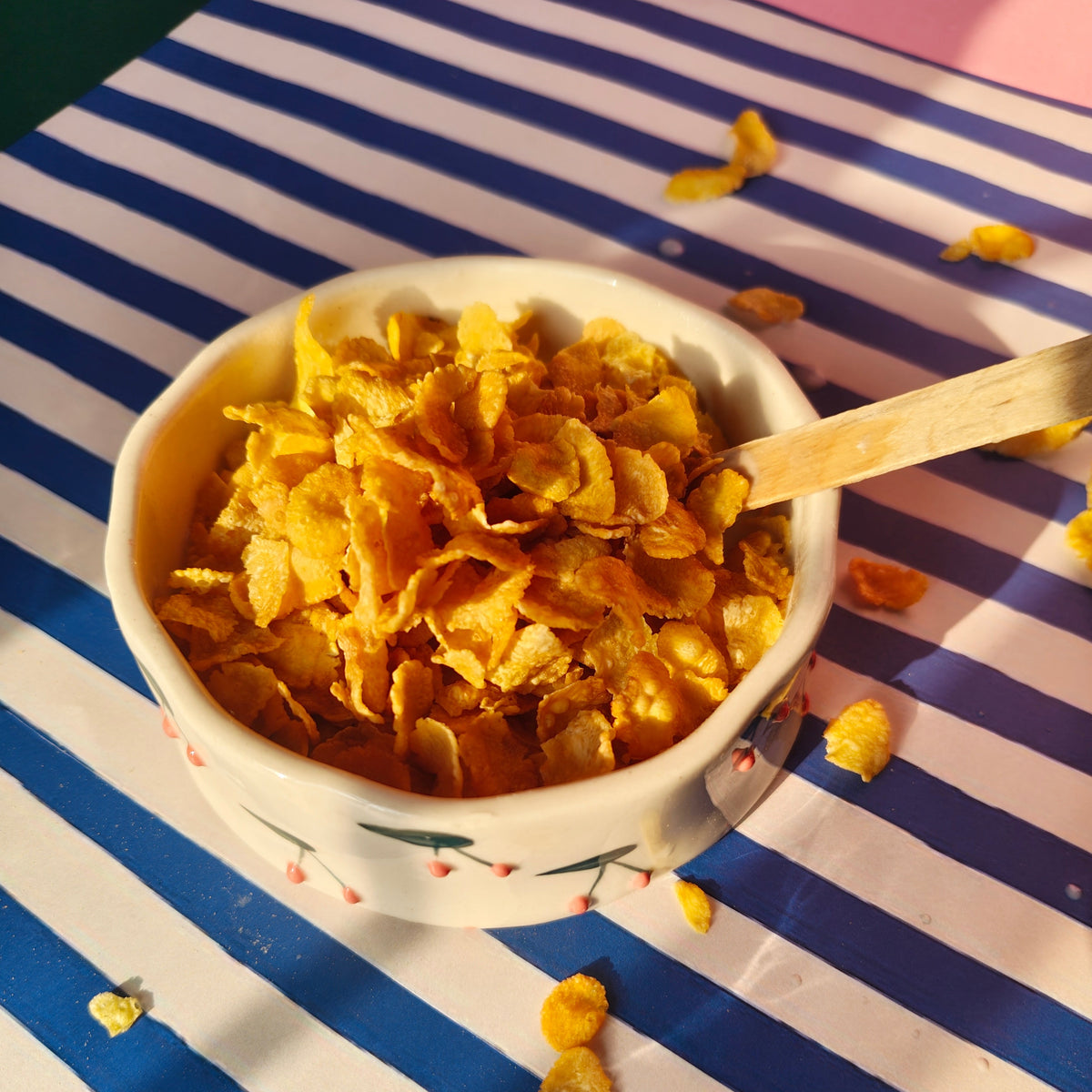 Snack bowl with cornflakes on a striped tablecloth