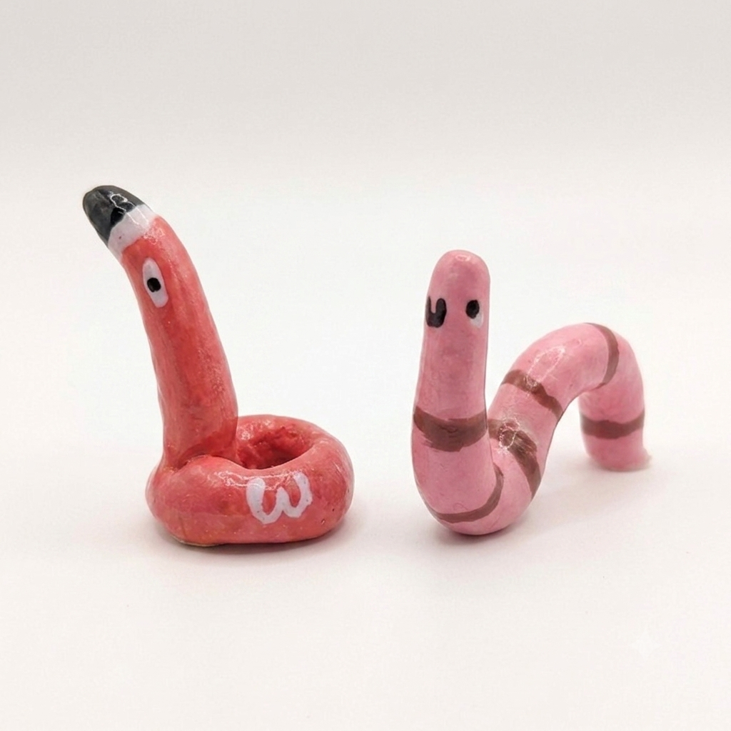Two pink snake-shaped ring holder on a white background