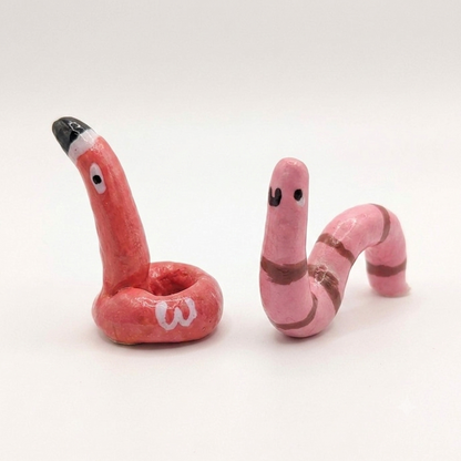 Two pink snake-shaped ring holder on a white background