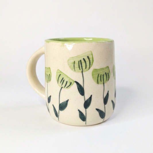 Ceramic mug with green floral design on a white background