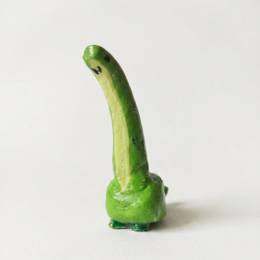 Green ring holder resembling a long-necked dinosaur on a white background