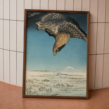 Framed artwork of a bird in flight with a mountainous landscape.