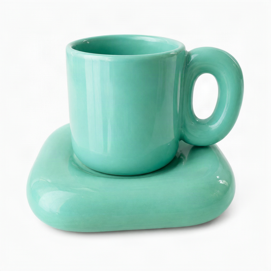 A glossy mint green ceramic coffee mug with a matching thick, rounded saucer, set against a plain white background.
