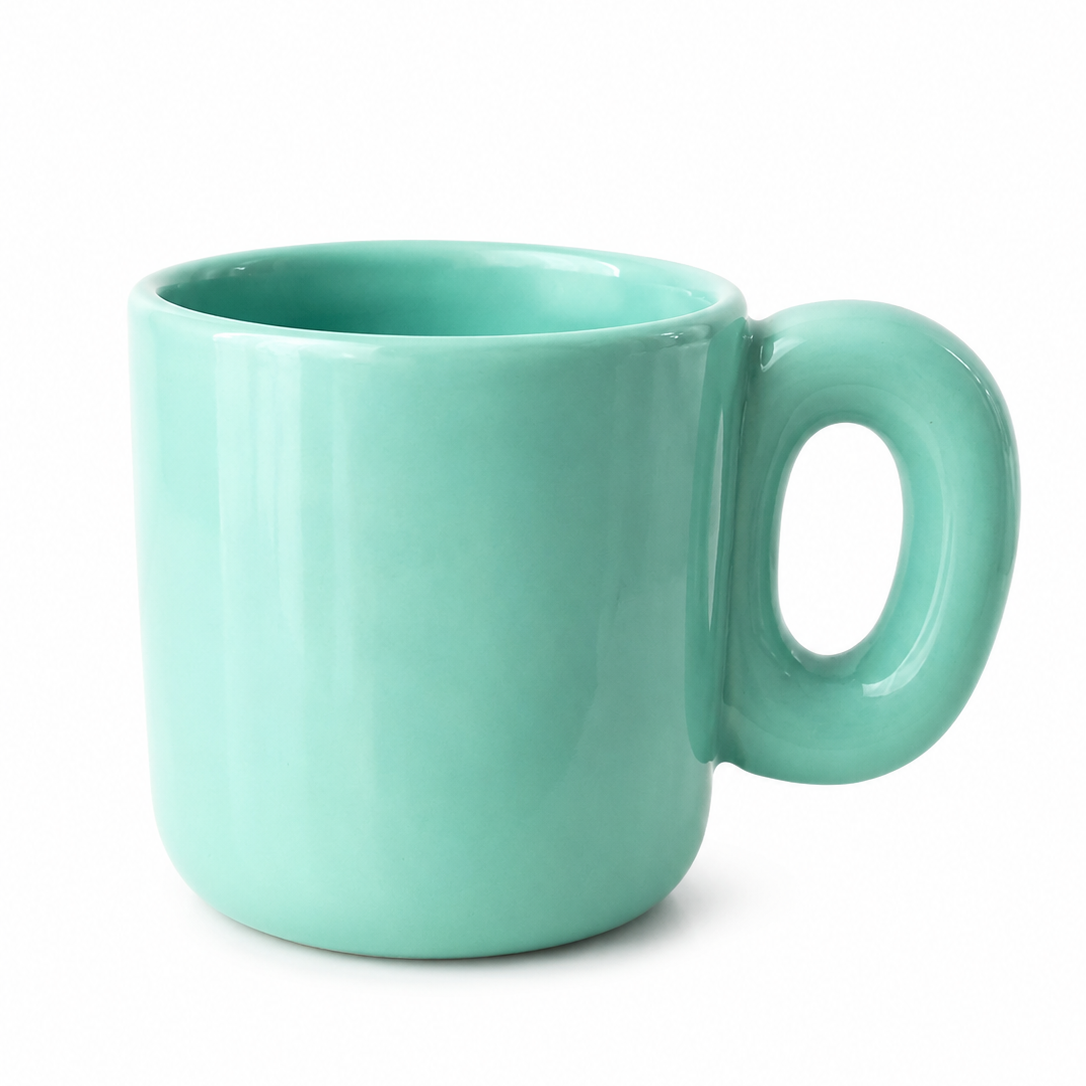 A mint green ceramic mug with a thick, rounded handle, shown on a clean white background.