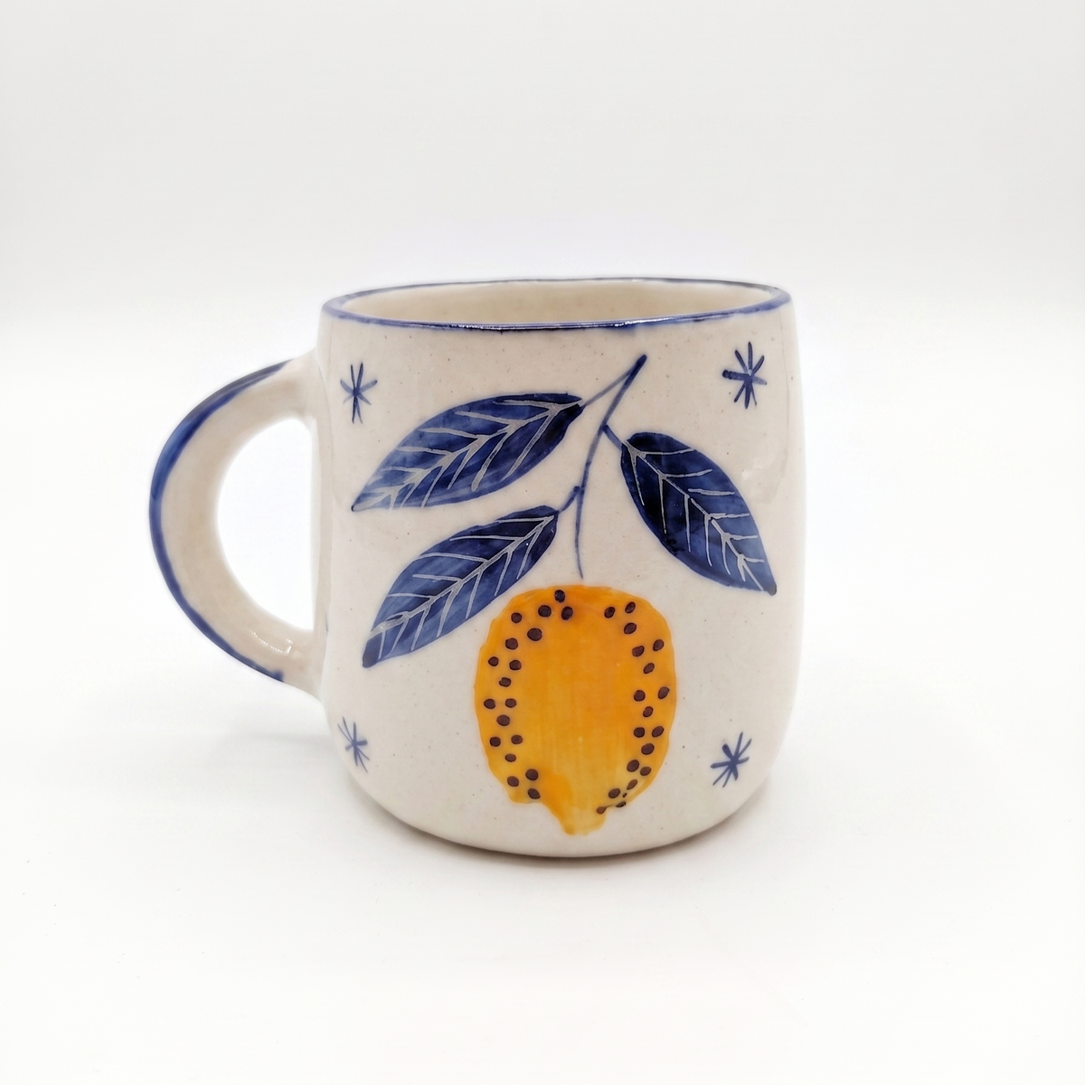 Ceramic mug with lemon and leaf design on a white background