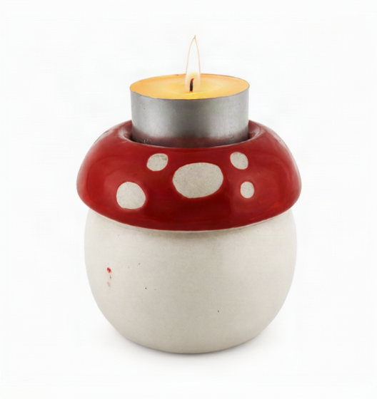 A mushroom-shaped candle holder with a red cap, white spots, and a white base, holding a lit silver tea light candle on a white background.