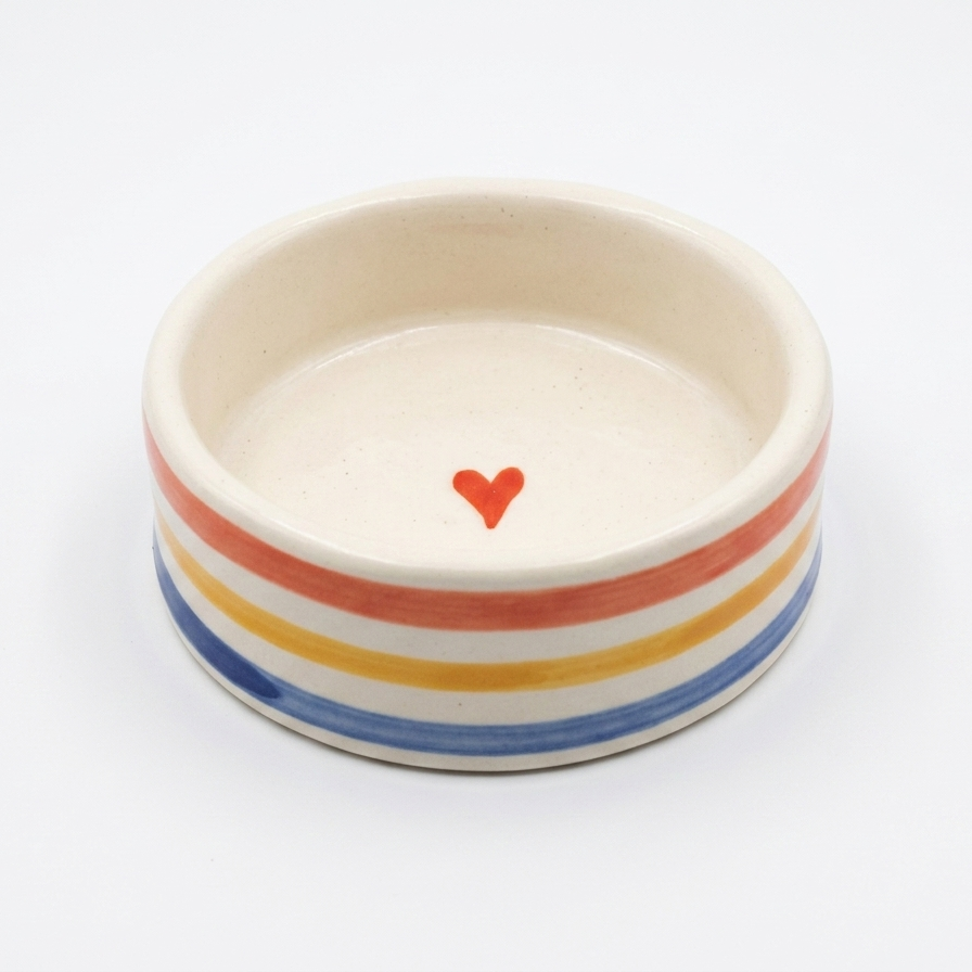 Ceramic bowl with rainbow stripes and a red heart on a white background