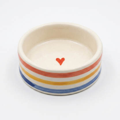 Ceramic bowl with rainbow stripes and a red heart on a white background