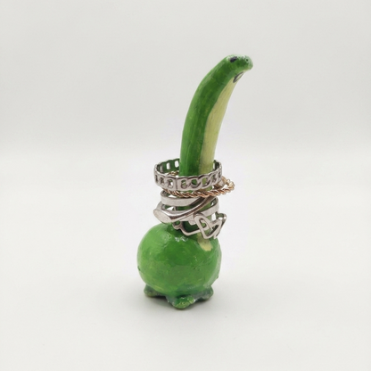 Green dinosaur with a ring on a white background