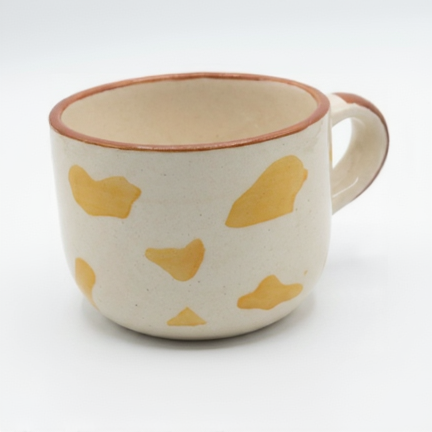 Ceramic mug with yellow abstract patterns on a white background