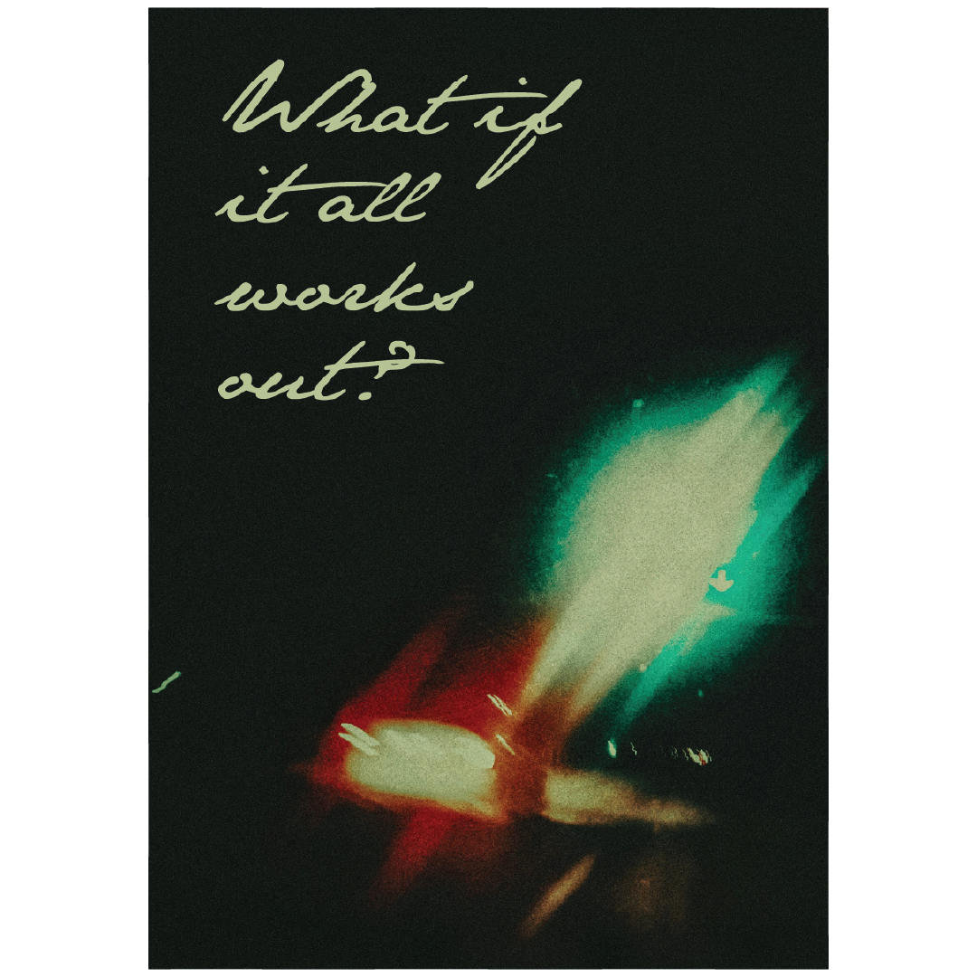 poster design on a white wall - the text reads what if it all works out with blurry traffic lights in the background