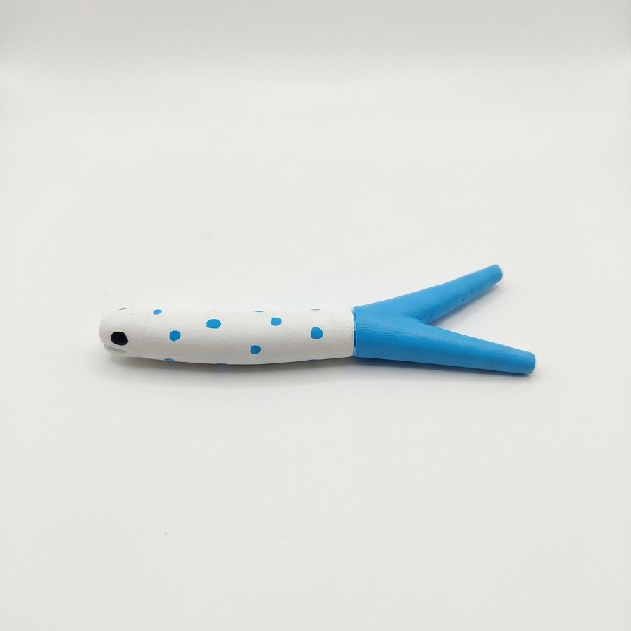 A small eel necklace holder with a white body, blue polka dots, and a bright blue forked tail, photographed on a plain light background.
